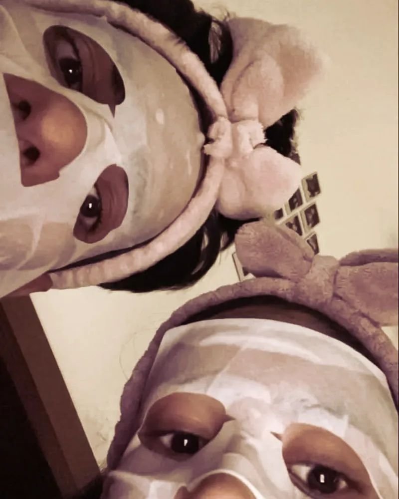 Una pareja con mascarillas faciales y diademas, tomándose una selfie